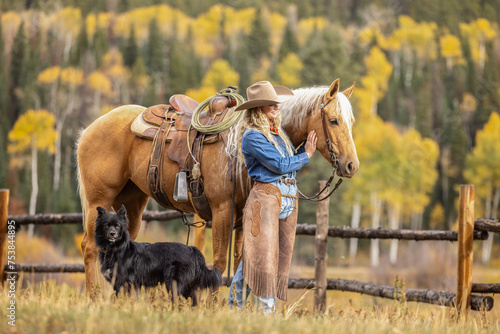 Fotografie Colorado Cowgirl with a palomino horse and her herding dog in the mountains with