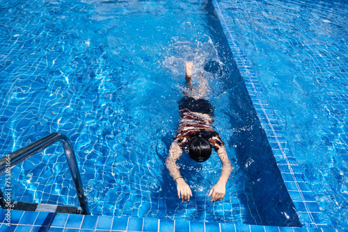 A girl enjoying swimming in a swimming pool photo