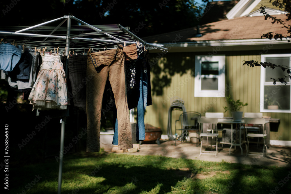 © Serena Burroughs/Stocksy - laundry hanging on drying rack in front of home