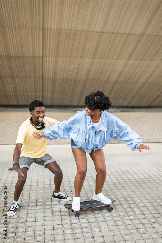 couple of black friends skating through the city couple of black friends skating through the city