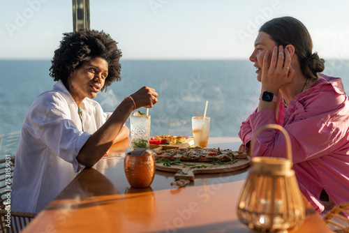 Two women talking while having dinner at the bar