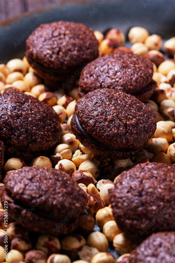 Baci de Alassio, Italian cookies made from nut dough filled with chocolate ganache on a background of shelled hazelnuts.