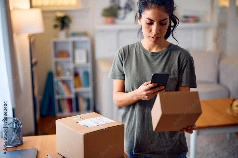 Hispanic woman using mobile app while rating her home delivery experience. Hispanic woman using mobile app while rating her home delivery experience.