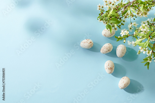 Holiday composition with spring flowers and easter eggs on a blue background. Happy easter flat lay concept with copy space