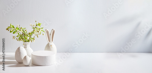 Empty round white podium for product presentation. Spring flowers in a vase and easter eggs on a light background