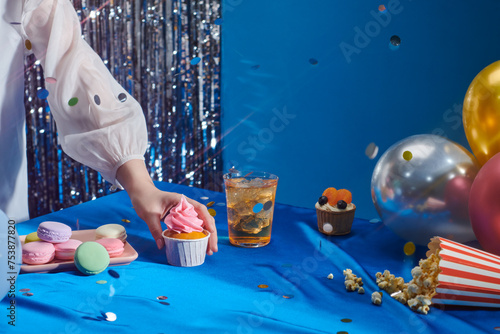 Party treats and items on table in room decorated with balloons photo