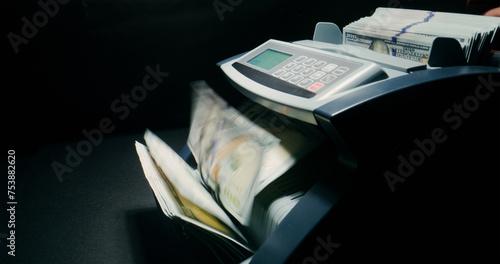 Hundred-dollar bills in the counting machine photo