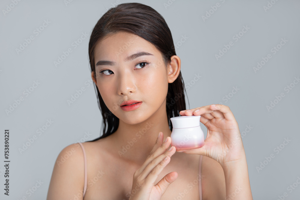Smiling woman shows jar of moisturizing cream on light background Smiling woman shows jar of moisturizing cream on light background