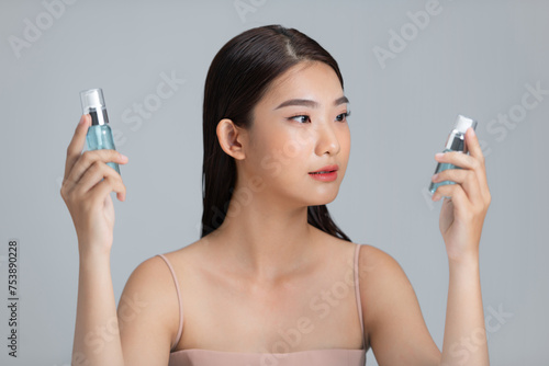 Woman with two serum bottles and choosing beauty skincare product photo