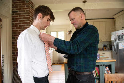 Father Helps Teen Son with Tie Dressing for Prom photo