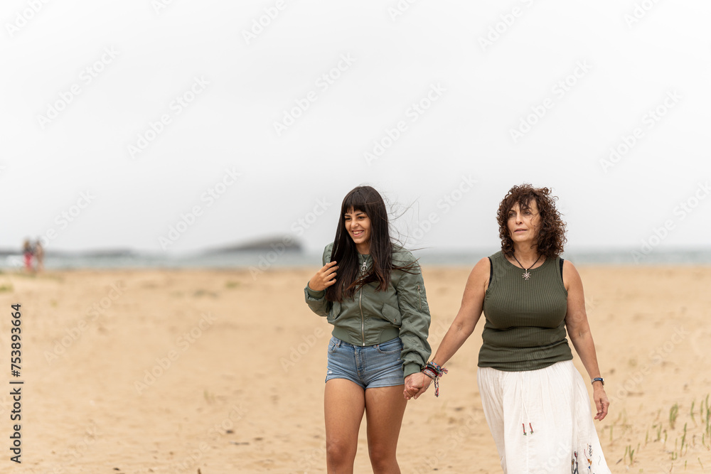 Mother and daughter walking at the beach. Mother and daughter walking at the beach.