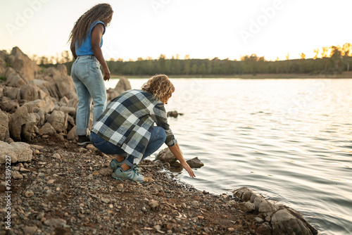 multiracial female friends by a river in nature