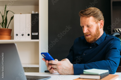 Man in Office Using Phone photo