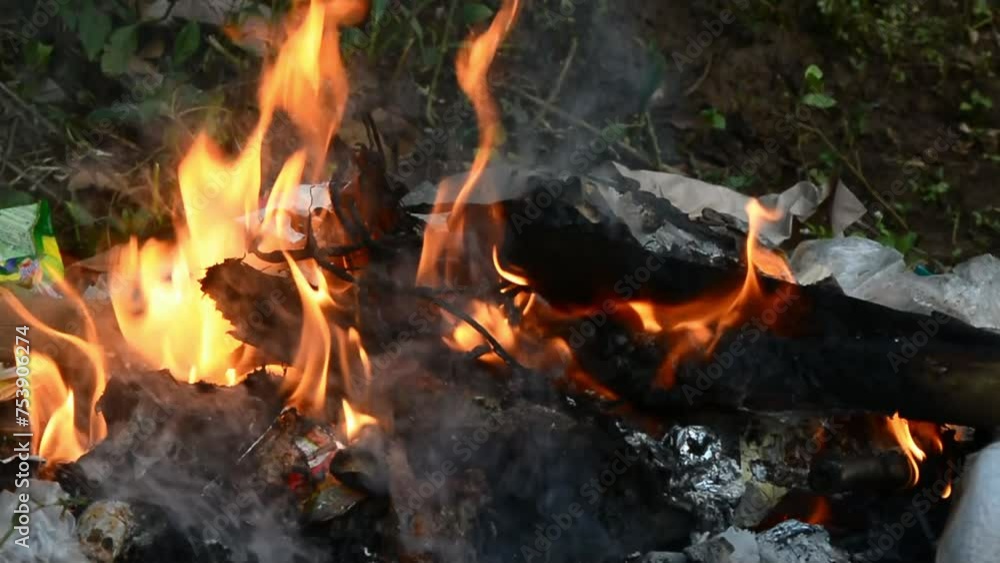 Close up of people burning plastic and paper waste Close up of people burning plastic and paper waste