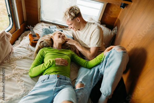 Young couple is lying on a bed in a van photo