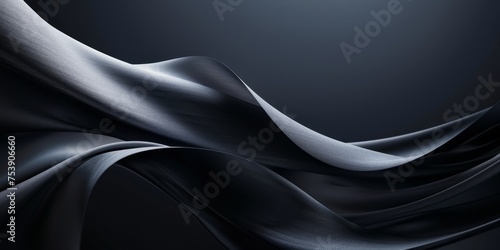 A black and white image of a long, flowing piece of fabric with a silver sheen