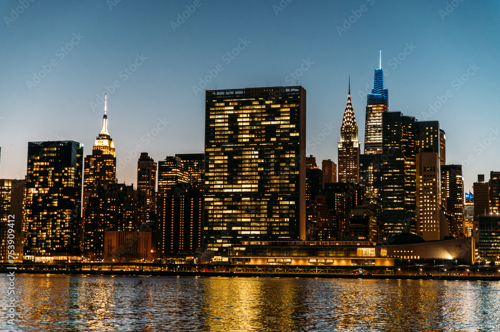 River surrounded by illuminated skyscrapers at twilight