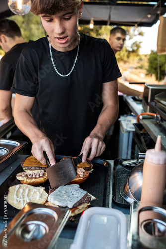Chef Assembling Deluxe Burgers in Food Truck