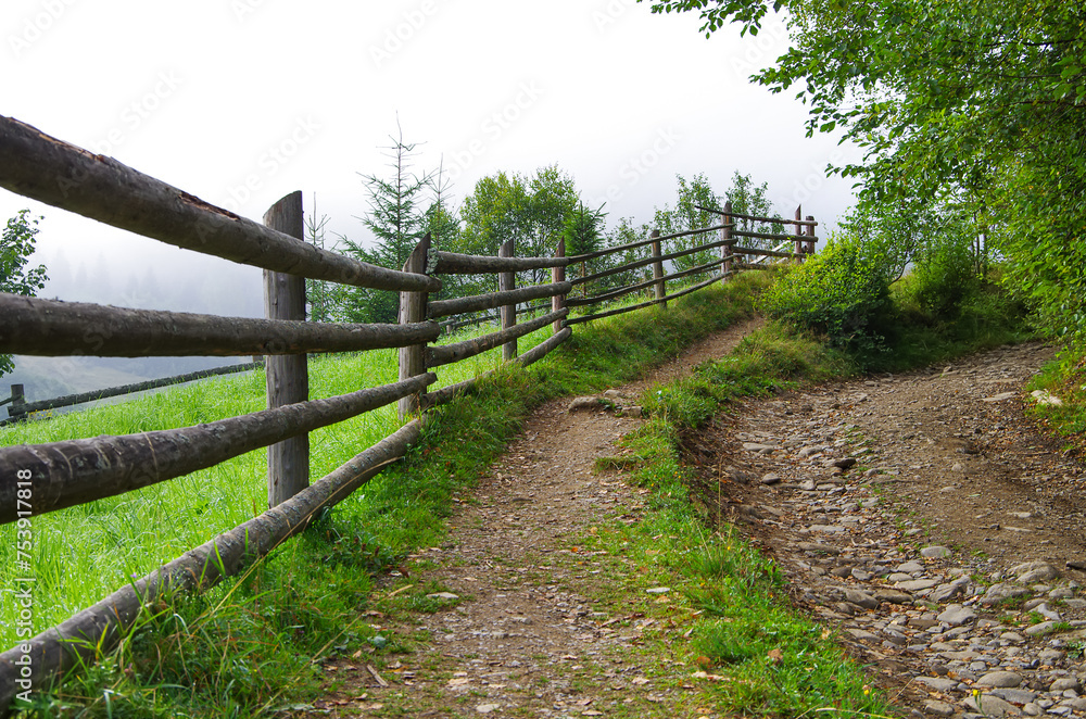 the road in the mountain near the wooden fence. rural landscape