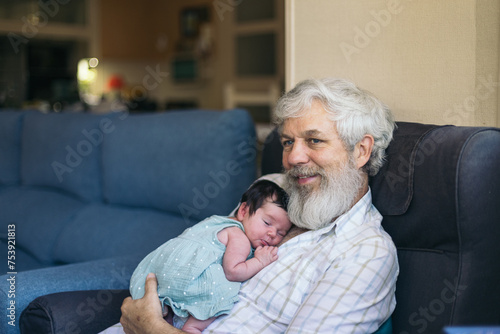 Newborn taking a nap with her grandfather photo