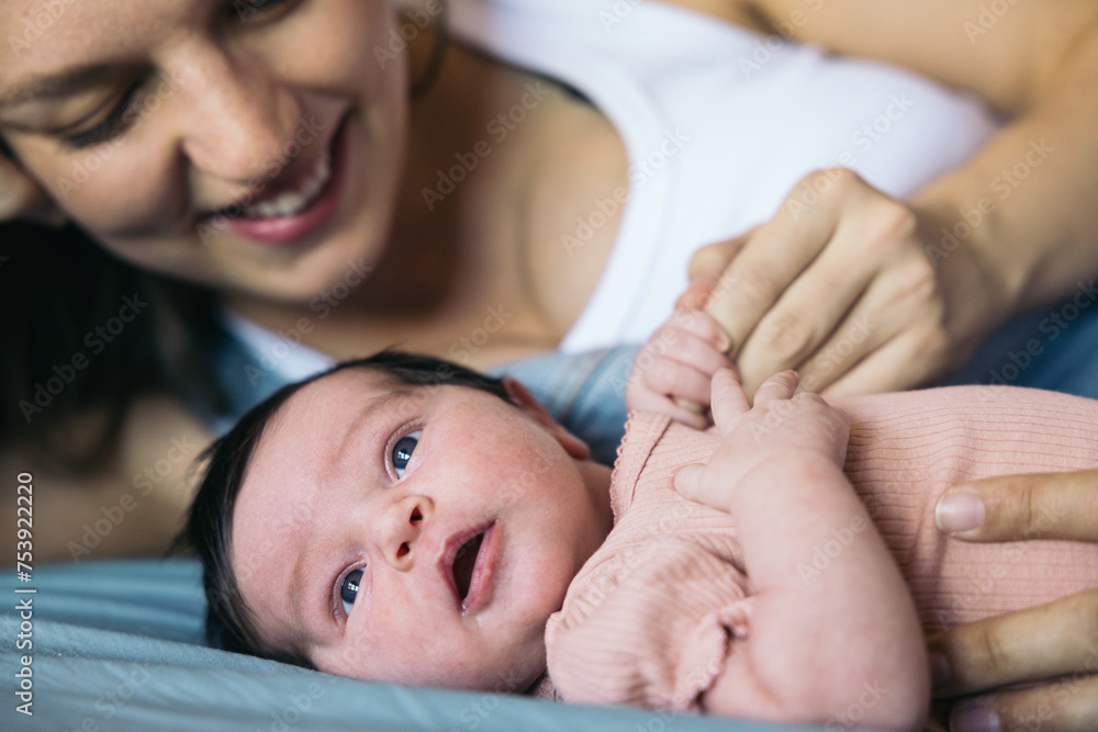 Close-up of a baby on the bed with her mother. Close-up of a baby on the bed with her mother.