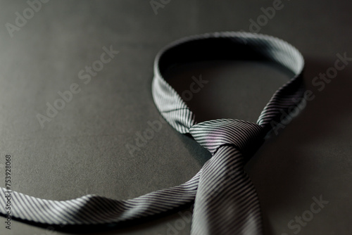 The grey tie and a bottle of cologne on a table next to a watch in an elegant setting. copyspace photo