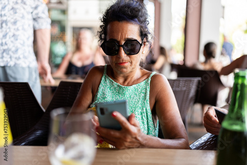 Woman using mobile phone in restaurant. photo