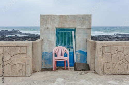 Blue door and red chair in a small building on the waterfront. photo