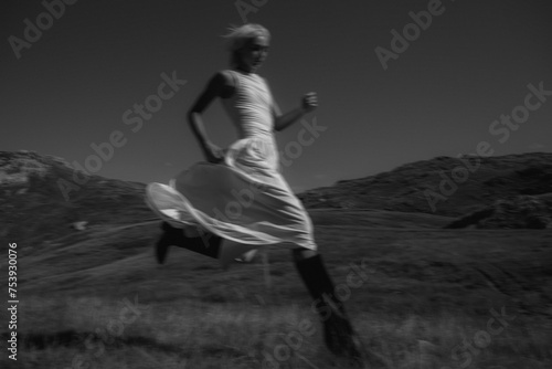 Artistic black and white photo of a model running in mountains