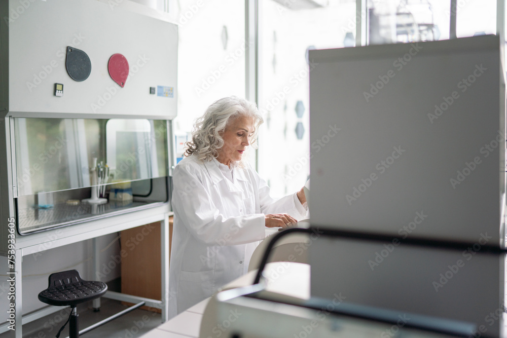 Senior Scientist Using Centrifuge In Modern Lab Senior Scientist Using Centrifuge In Modern Lab