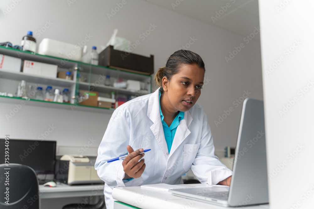 Scientist Using Computer And Writing Notes Scientist Using Computer And Writing Notes