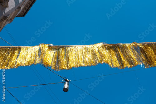 Golden shiny festival party ribbon and clear blue sky photo