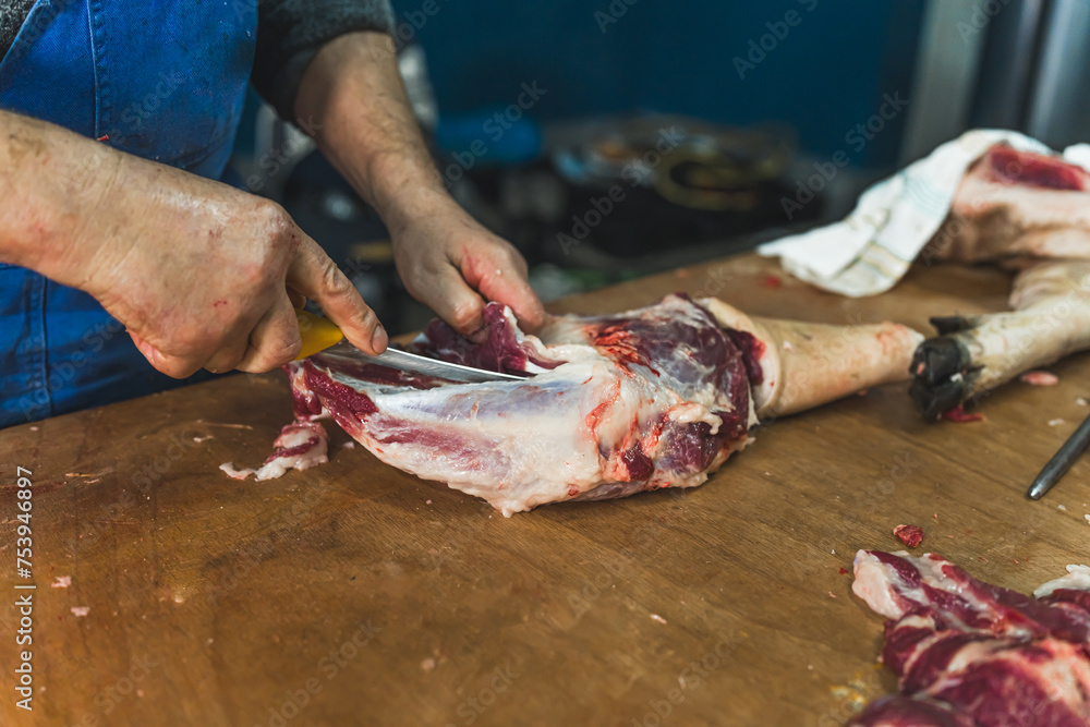 close-up of meat processing in the food industry, the worker cuts raw pig. High quality photo