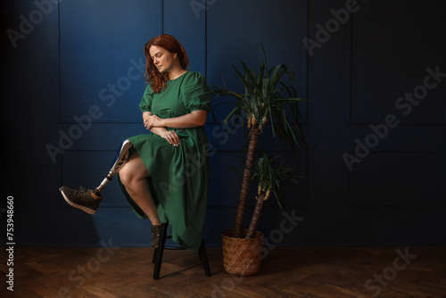 Dramatic portrait of a disabled woman with a prosthetic leg photo