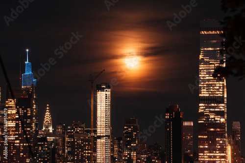Glimpse of Uptown Manhattan: Full moon gracing the iconic skyline with photo
