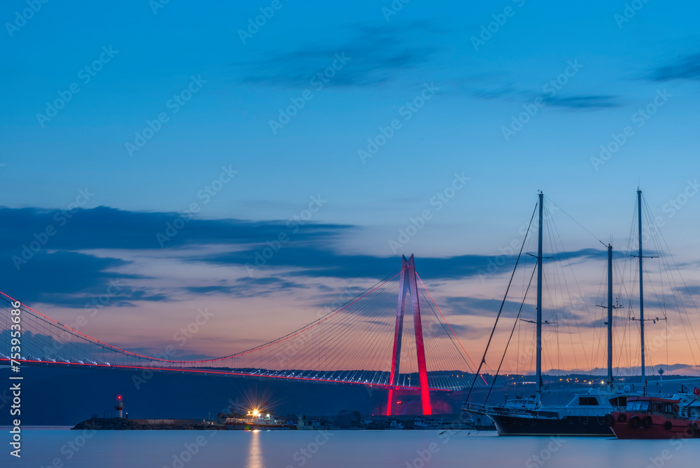 istanbul yavuz sultan selim bridge taken from the beach towards sunset people dogs with blue sea and sky and evening lighting istanbul yavuz sultan selim bridge taken from the beach towards sunset people dogs with blue sea and sky and evening lighting