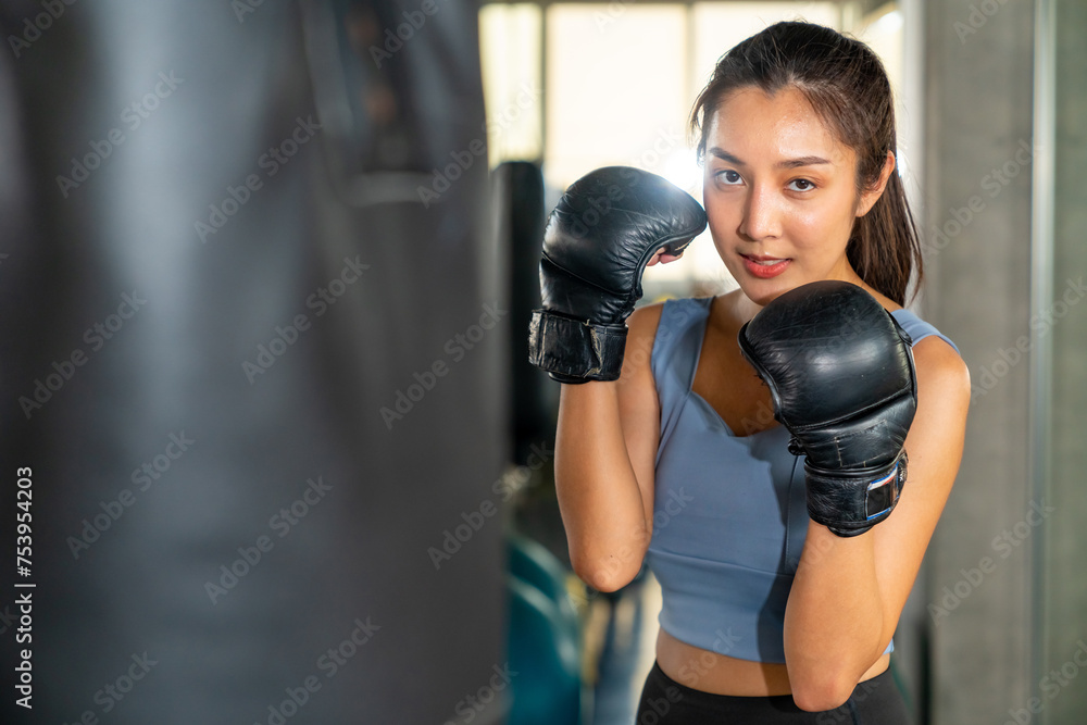 Healthy Asian woman do sport training workout boxing exercise with punching bag at fitness gym. Active sportswoman practicing fighting exercise kickboxing at sport club. Health care motivation concept Healthy Asian woman do sport training workout boxing exercise with punching bag at fitness gym. Active sportswoman practicing fighting exercise kickboxing at sport club. Health care motivation concept
