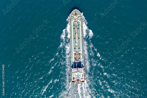 Aerial top view of cargo maritime ship with contrail in the ocean ship carrying container and running for export concept technology freight shipping by ship forwarder mast 