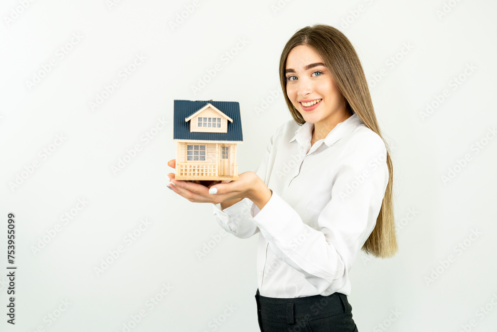 Young caucasian woman holding a house model isolated on white background Young caucasian woman holding a house model isolated on white background