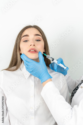 Photo of beautiful woman getting mesotherapy treatment in face by specialist in gloves in beauty salon