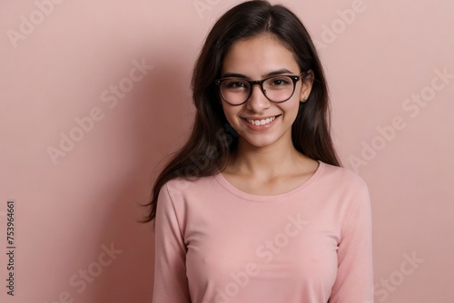 Happy young Brazilian woman with glasses on a pink background with copy space.