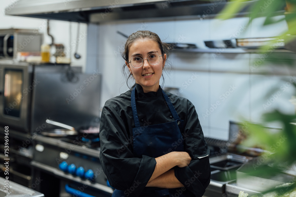 Woman standing in kitchen with crossed hands Woman standing in kitchen with crossed hands