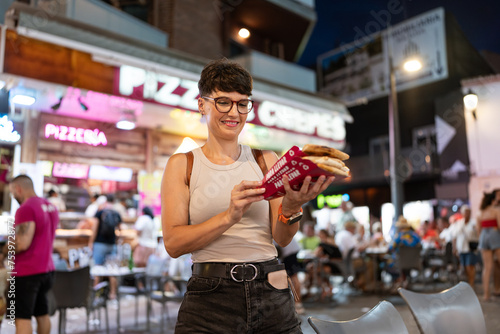 Woman holding takeaway pizza slices. photo