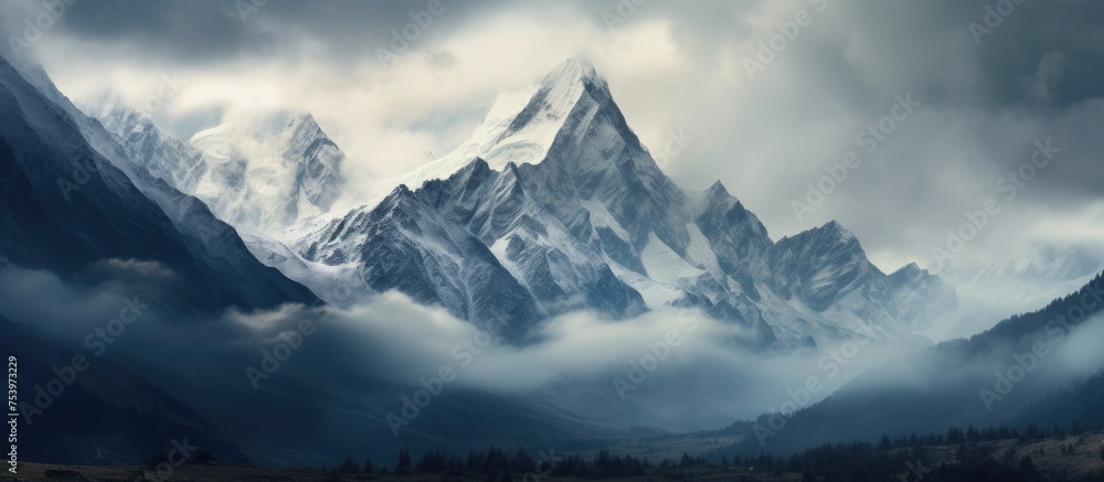 Obraz premium A painting depicts majestic mountain peaks shrouded in mist with dramatic clouds swirling in the sky, creating a scene of grandeur and mystery.