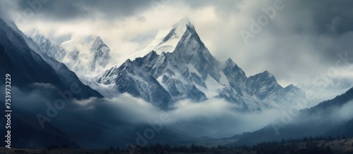 A painting depicts majestic mountain peaks shrouded in mist with dramatic clouds swirling in the sky, creating a scene of grandeur and mystery.