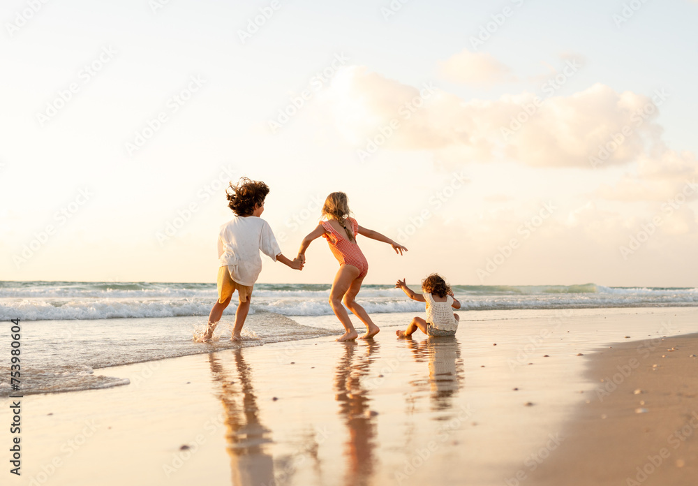 Siblings running on an empty beach. Siblings running on an empty beach.