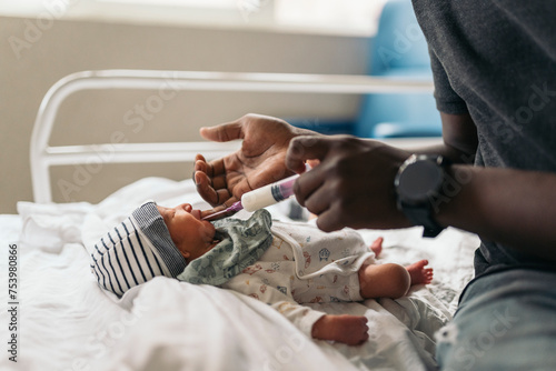 Feeding a baby with formula milk in a hospital room photo