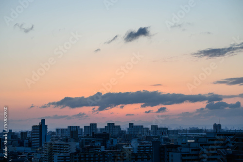 生駒山系から朝日が昇る時。神戸市内から芦屋のビルと山並みをシルエットで撮影。