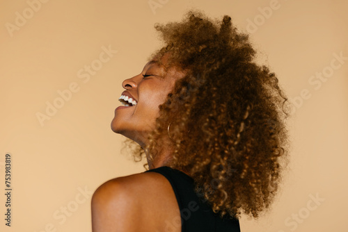 Cheerful woman with curly hair in studio photo