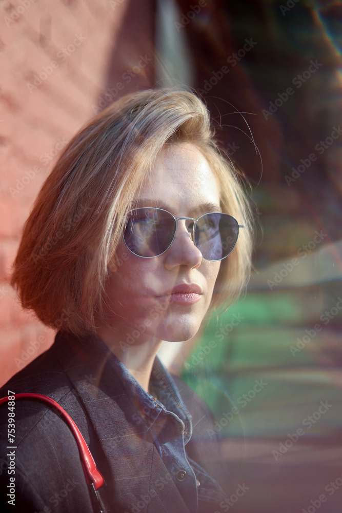 Elegant model wearing sunglasses on a sunny day with light effect Elegant model wearing sunglasses on a sunny day with light effect